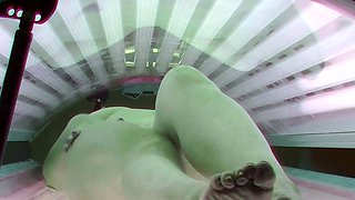 Busty MILF masturbates in solarium