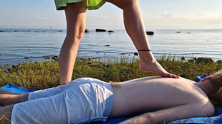 Foot massage by girl with long toes, long slim legs in skirt