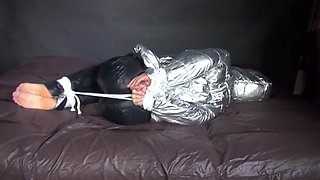 Watching Sexy Sandra Being Tied And Gagged On A Bed With Ropes And A Ballgag Wearing A Supersexy Shiny Black Nylon Pants And A Silver Down Jacket (Video)